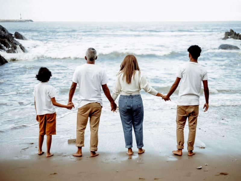 Family at the beach, looking at the sea.